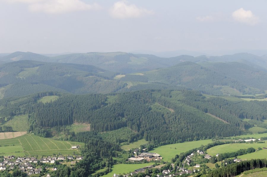 Luftaufnahme von Fleckenberg im Schmallenberger Sauerland mit bewaldeten Höhenzügen im Hintergrund
